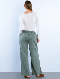 Back view of sage green corduroy wide-leg pants showcasing elastic waistband and pockets