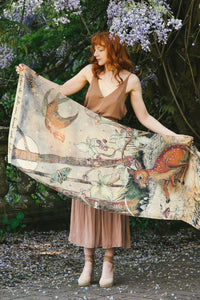 Woman in forest wearing illustrated woodland animals scarf around shoulders
