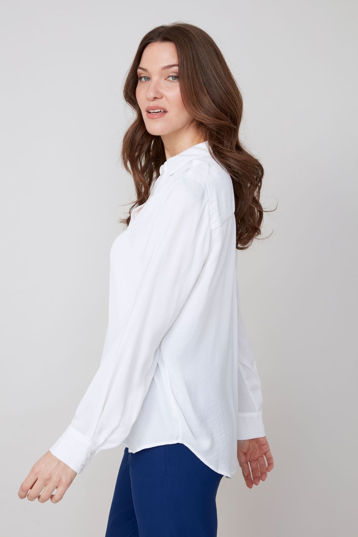 Side view showing the drape of the white button-up blouse