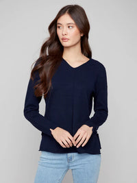 Woman modeling navy v-neck sweater looking to the side