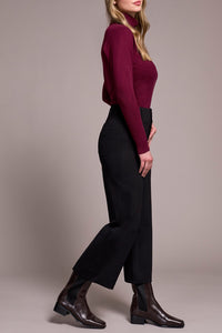 Side view of woman in wide-leg black pants and burgundy sweater
