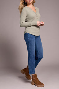 Woman in straight-leg blue jeans and taupe henley top, side view