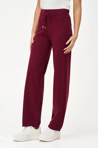 Woman showing side view of burgundy relaxed-fit knit jogger pants