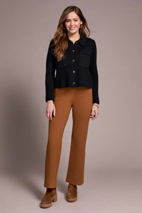 Woman smiling in caramel straight-leg pants paired with a chic black sweater and chunky brown shoes