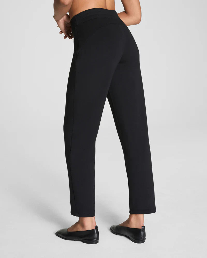 Back view of black stretch tapered pants displaying streamlined silhouette