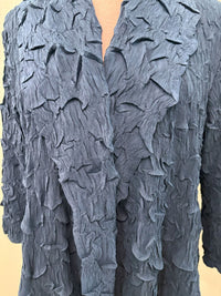 Close-up showing textured crinkled blue fabric and detailed collar