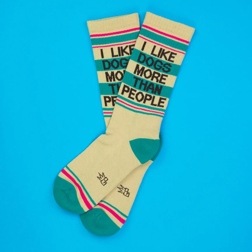 Two cream socks with colorful stripes and 'I Like Dogs More Than People' in bold letters