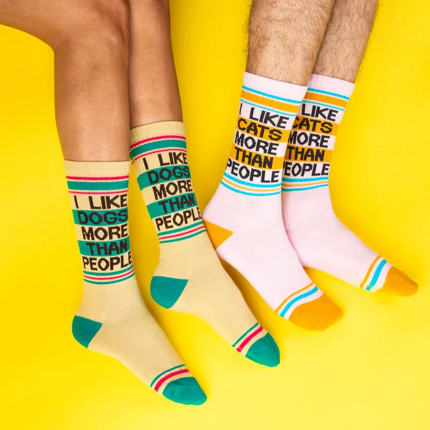 Comparison of two people wearing 'I Like Dogs More Than People' and 'I Like Cats More Than People' socks