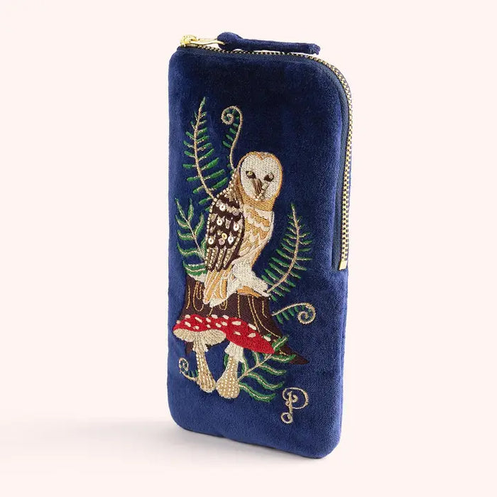 Close-up of navy velvet pouch featuring owl and mushroom embroidery with gold zipper