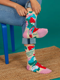 Person wearing colorful Menopause WTF floral socks while sitting on a blue chair