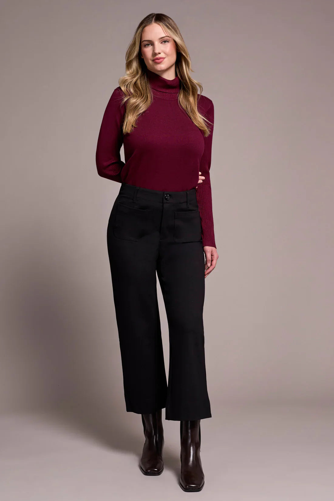 Model wearing wide-leg black dress pants with burgundy turtleneck