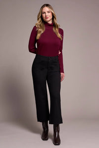 Model wearing wide-leg black dress pants with burgundy turtleneck