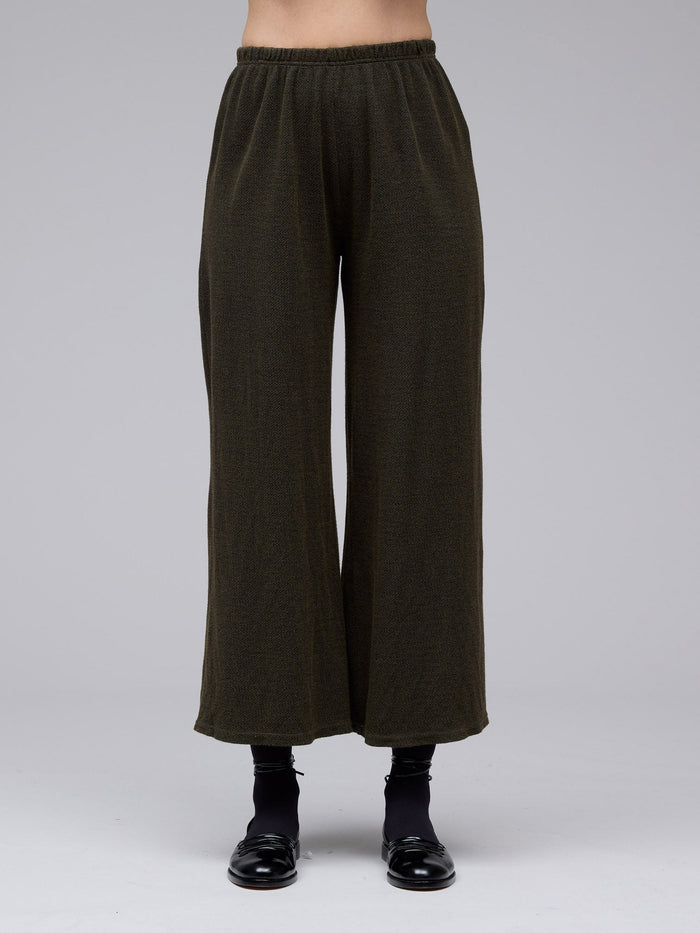 Model wearing wide-leg dark olive knit pants with elastic waist