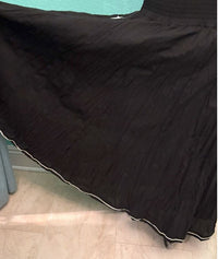 Wide black maxi skirt with white trim held out to show fullness