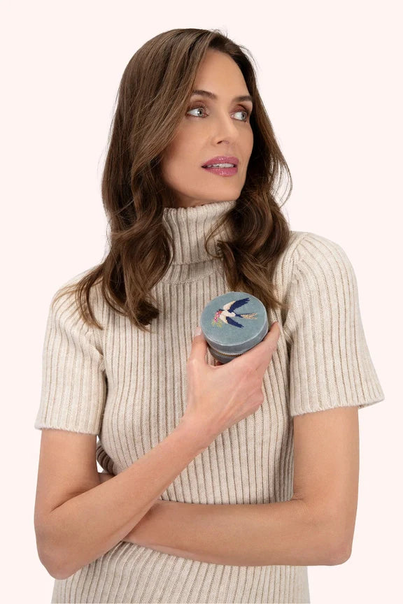 Woman holding a stylish round embroidered velvet jewelry case