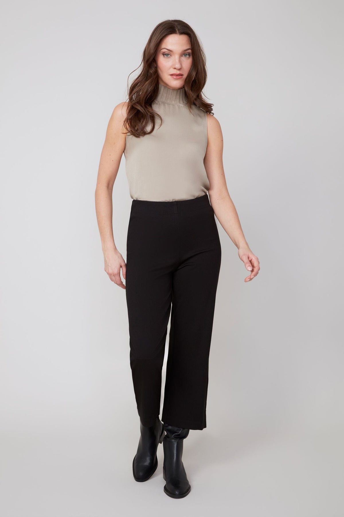 Front view of woman wearing chic black wide-leg cropped pants with boots
