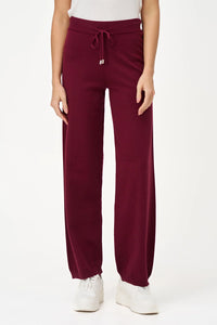 Burgundy knit jogger pants with drawstring laid flat on a white background