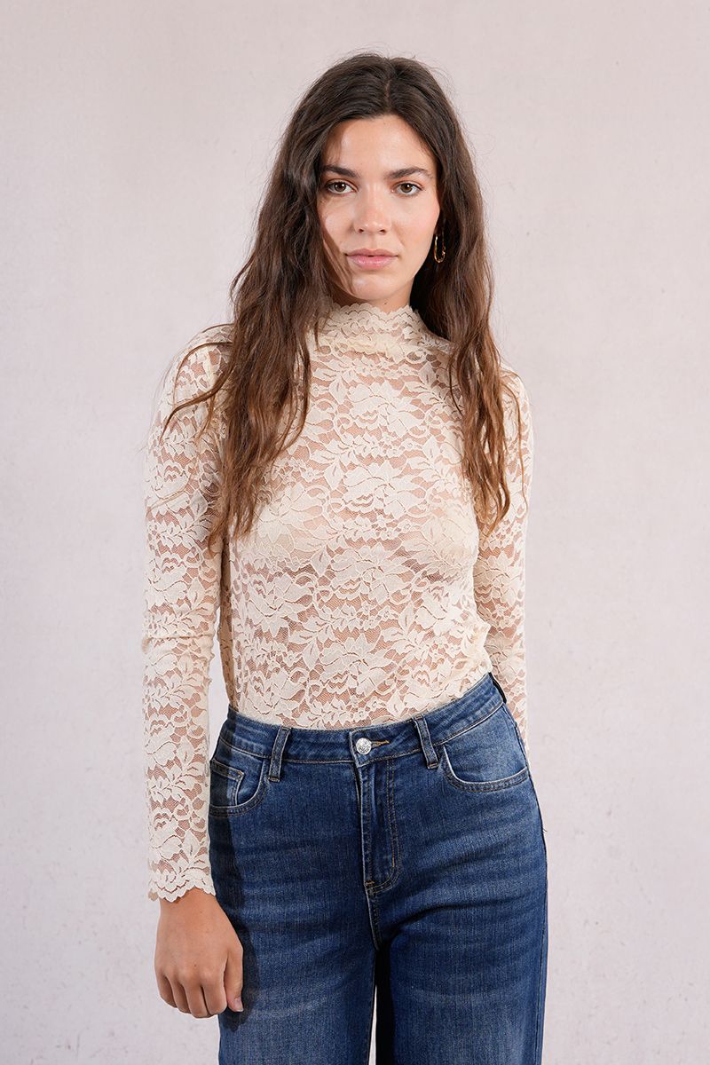 Front portrait of woman in an ivory lace mock neck top with jeans