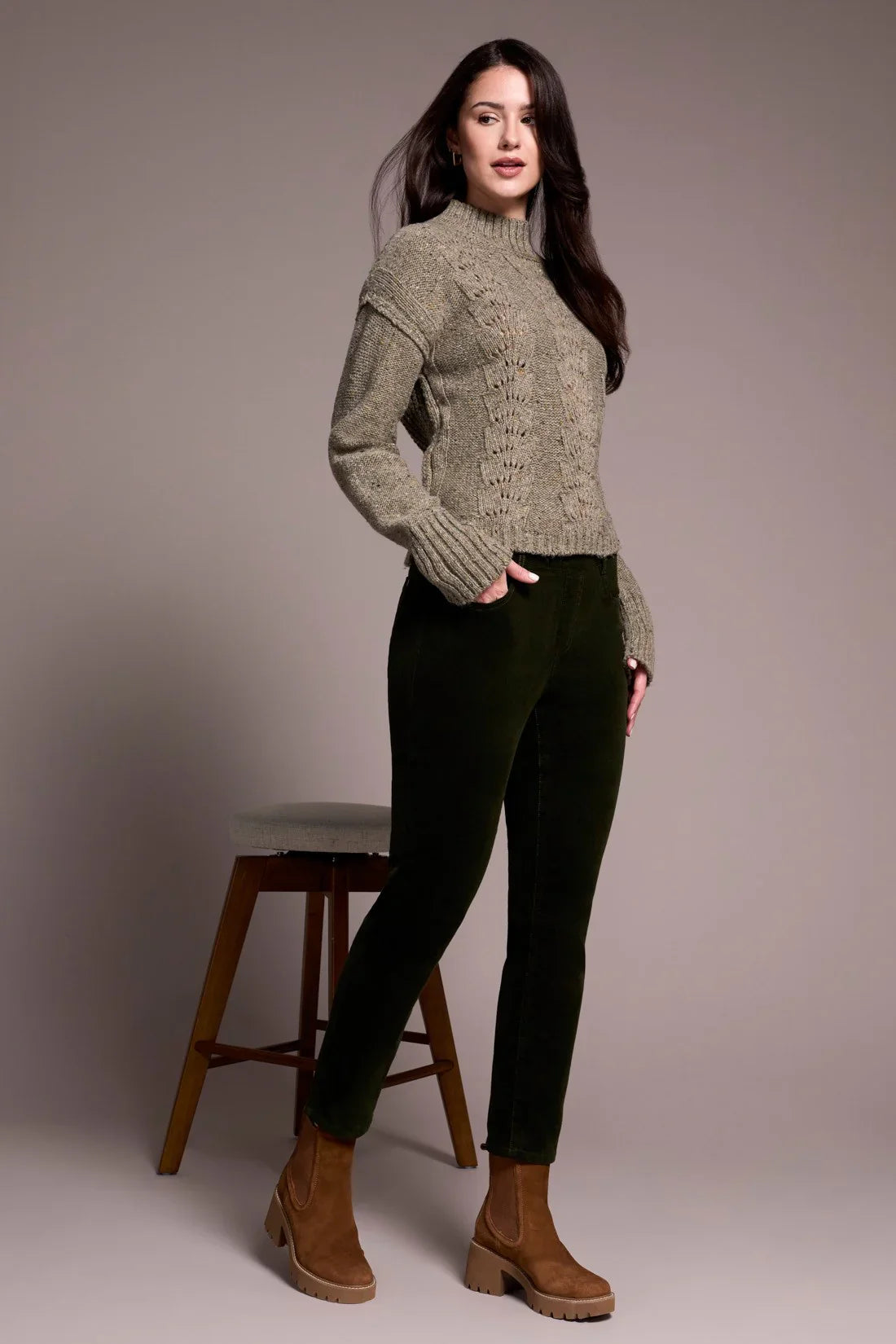 Stylish woman in olive corduroy pants and brown boots, side pose