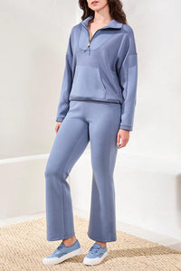 Full body image of woman in soft blue lounge set with kangaroo pocket and sneakers