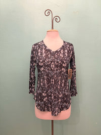 Front view of a women's floral mosaic V-neck top with 3/4 sleeves on a mannequin